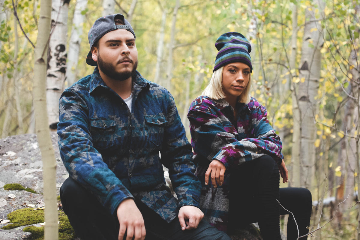 couple sitting in forest wearing grassroots gear