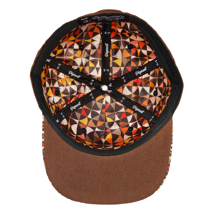 Fitted hat interior with black geometric patchwork lining and orange patterned crown.