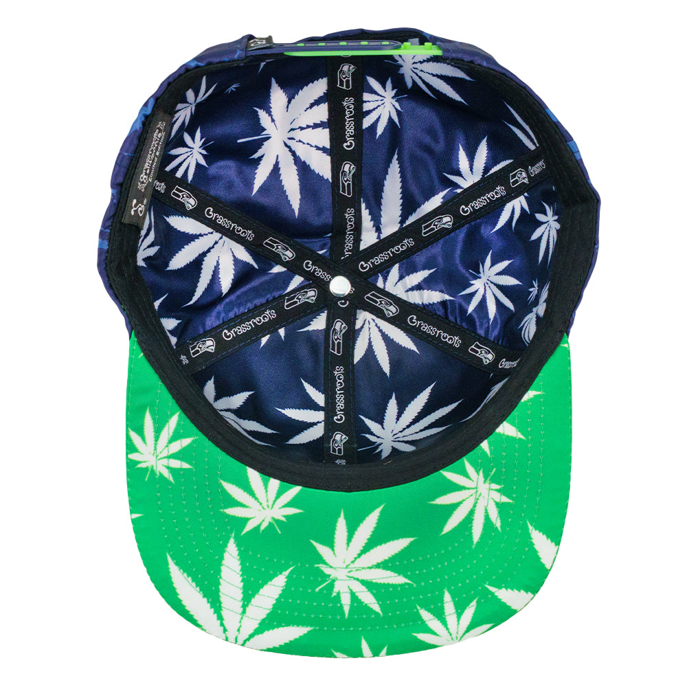 Navy snapback hat with green underside and cannabis leaf print band across crown.