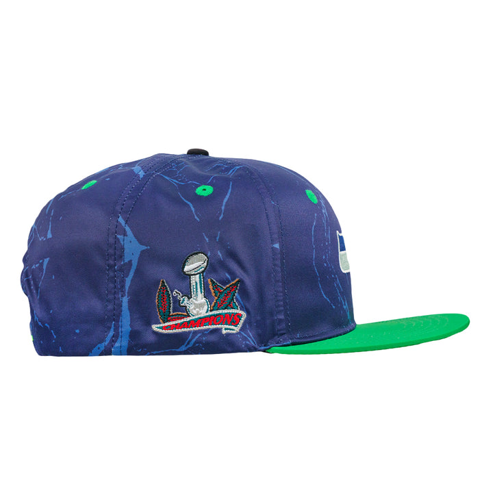 Navy snapback hat with champions emblem and green flat brim