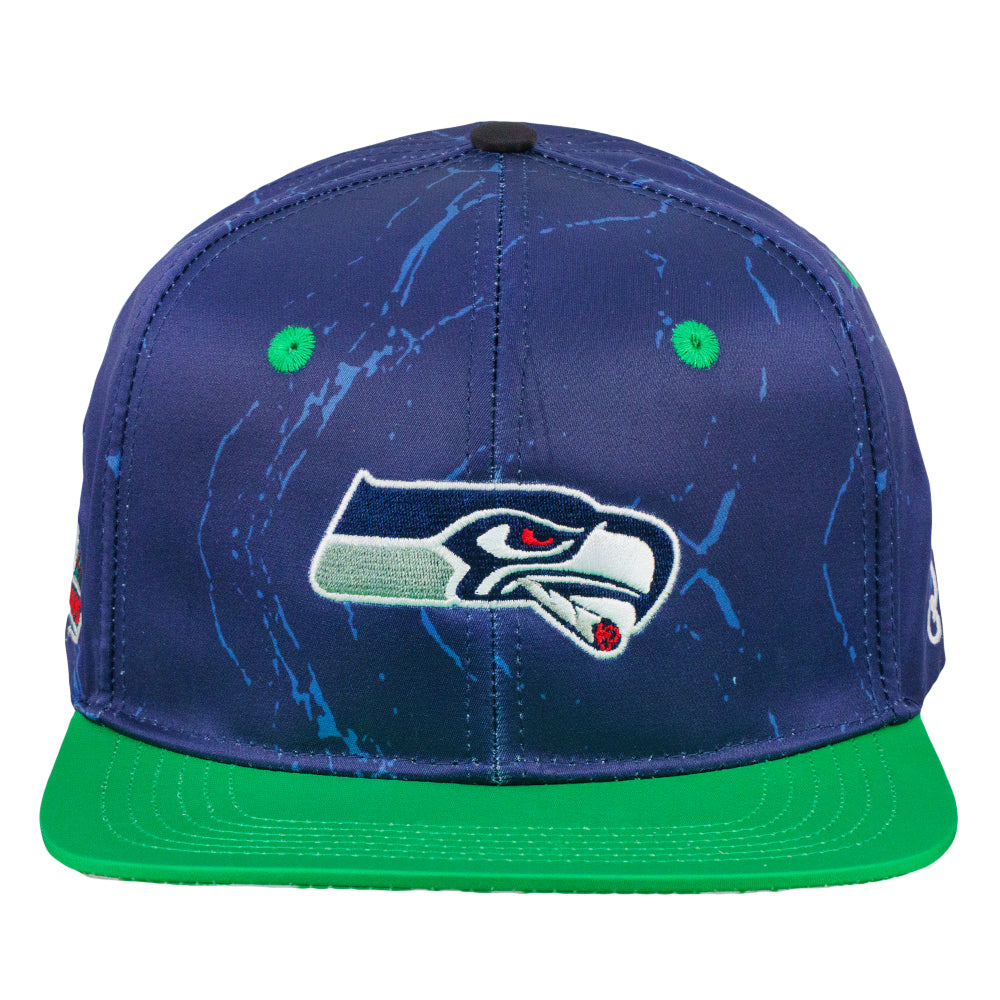Navy snapback hat with hawk logo and green brim, blue splatter design