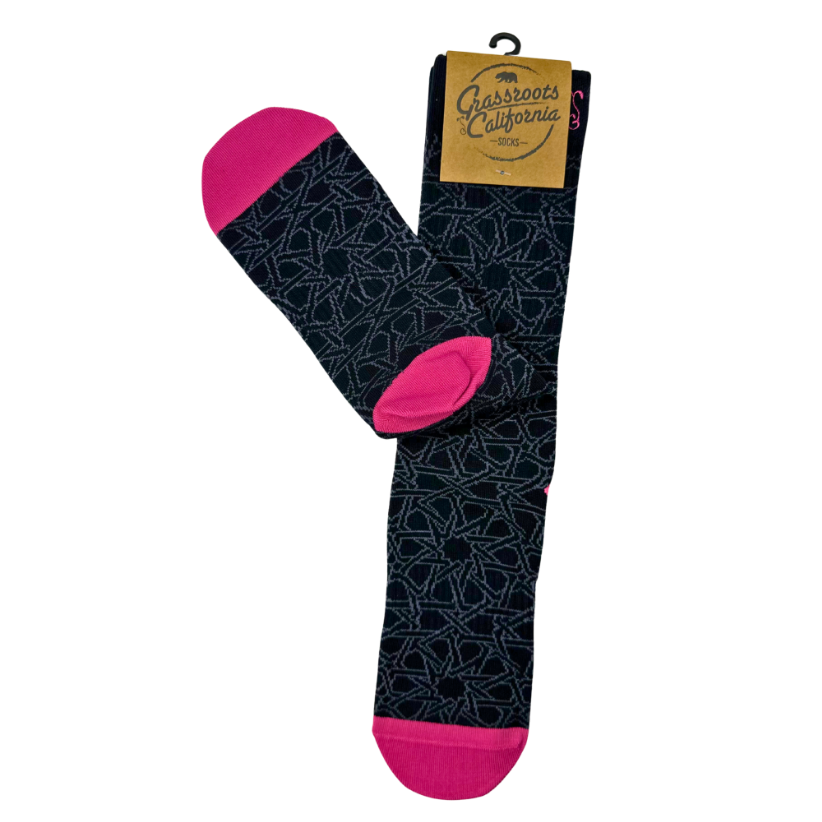 Black socks with geometric pattern and bright pink toe and heel, shown folded