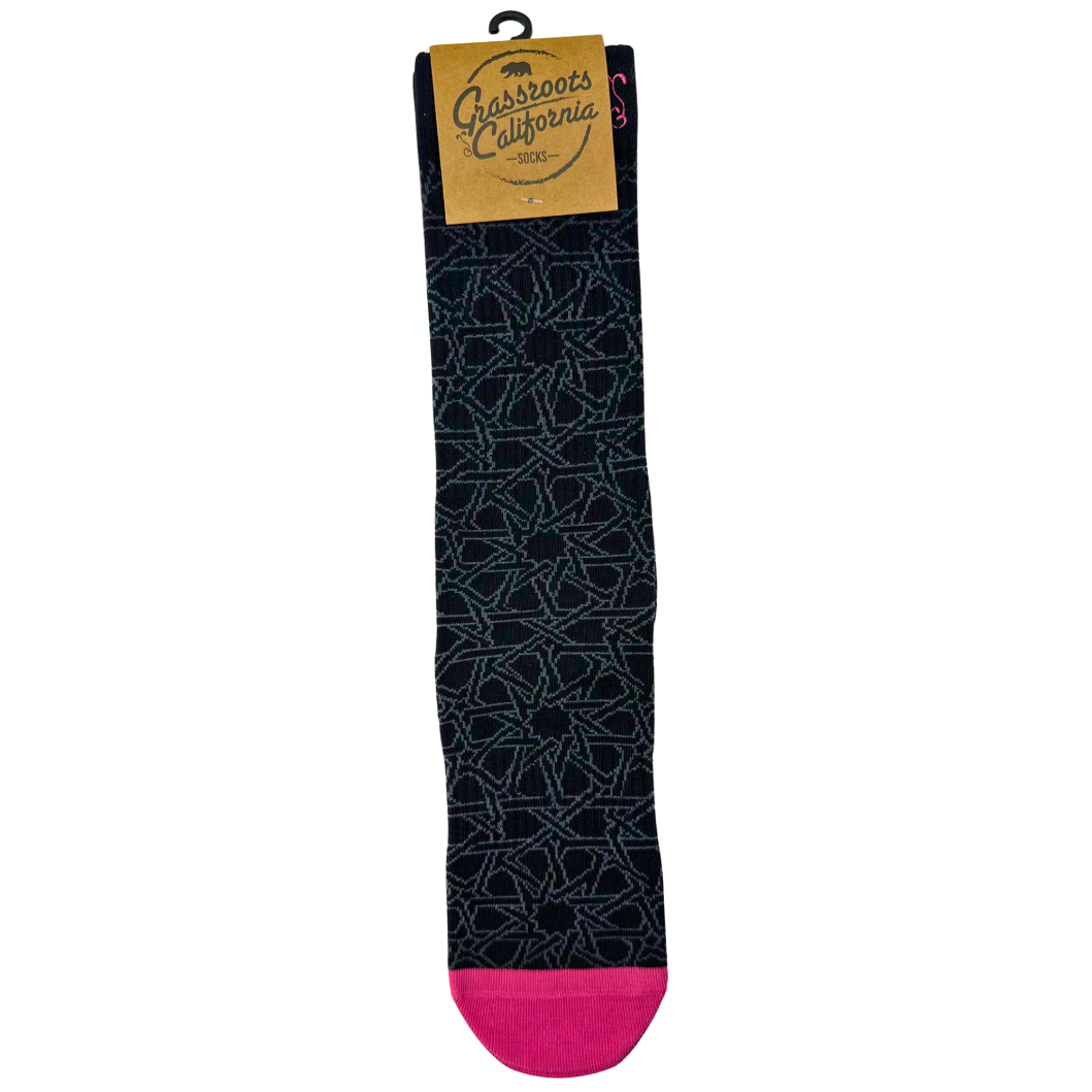 Black socks with geometric pattern and bright pink toe, heel, and cuff accents