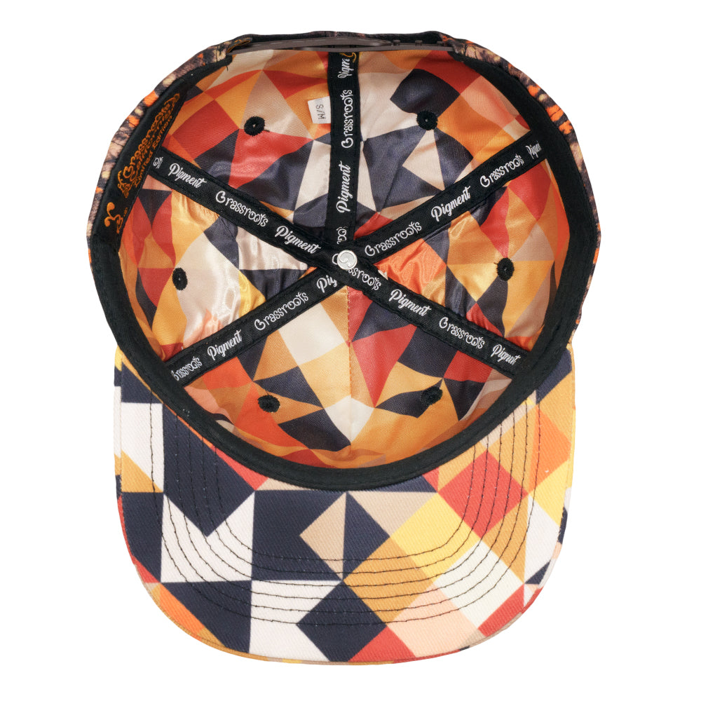 Snapback hat with interior black mesh lining and geometric patchwork print under brim.