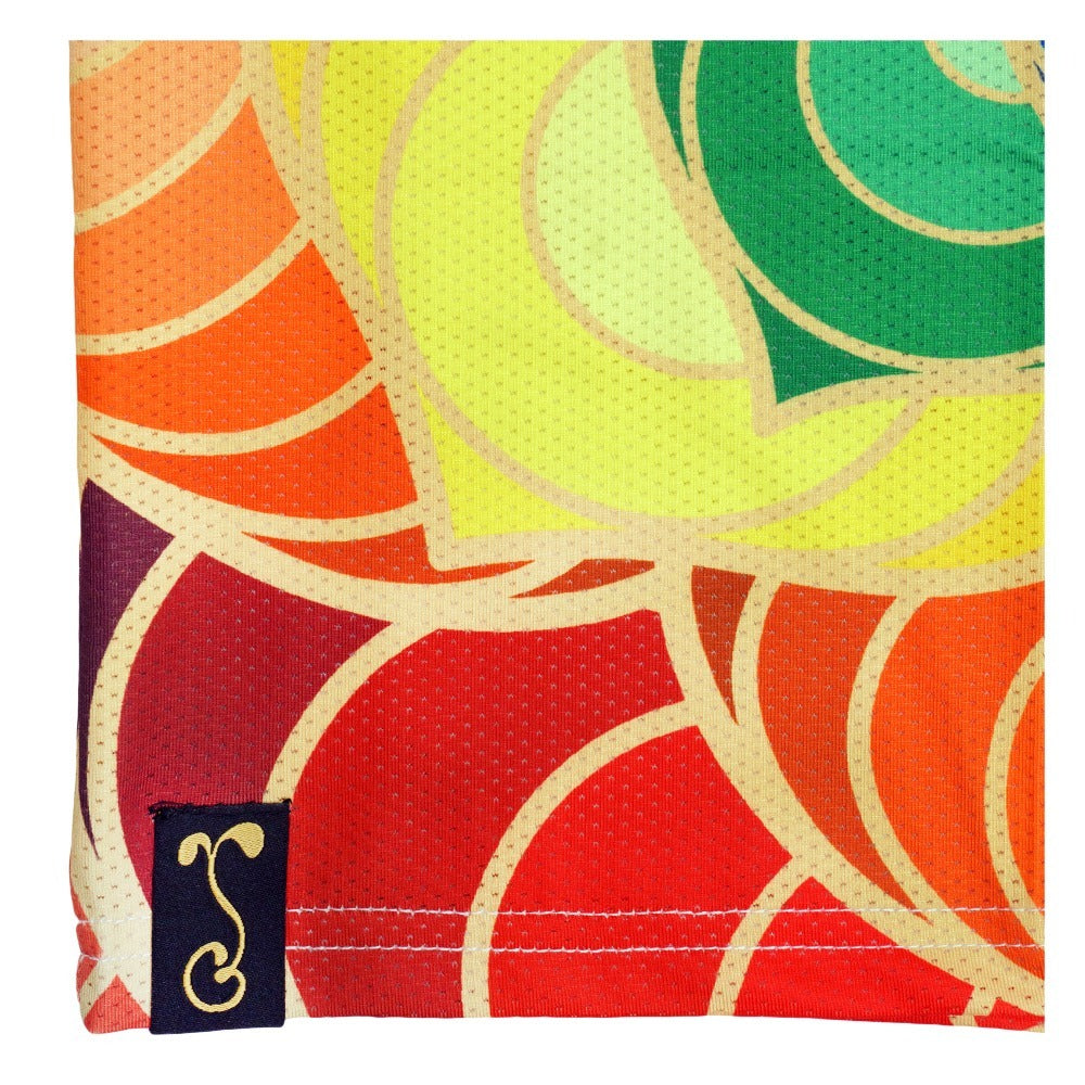 Multicolor t-shirt fabric closeup with geometric chakra pattern and logo label