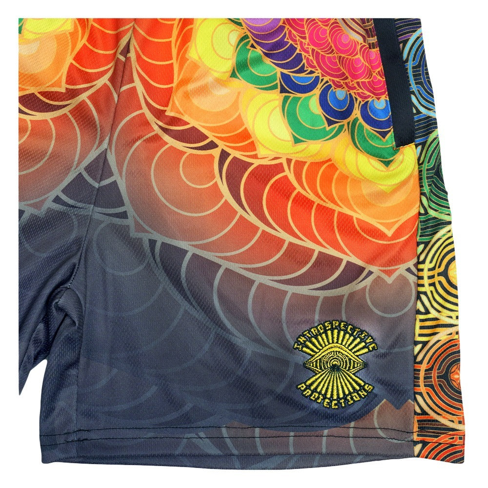 Mesh shorts close-up: orange-red scales, GRC emblem on dark gray fabric