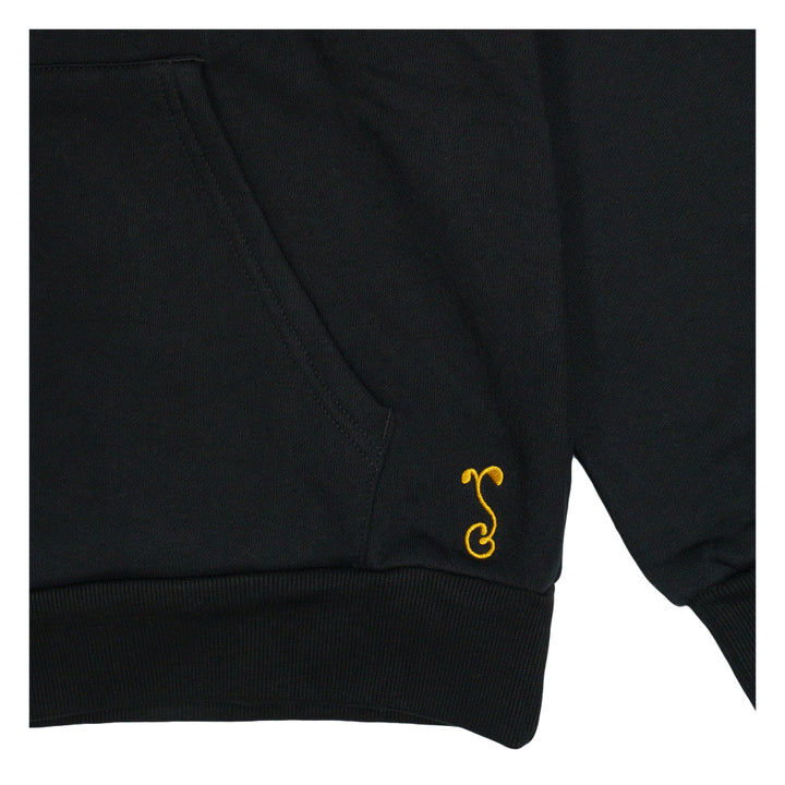 Black pullover hoodie sleeve cuff with small yellow emblem