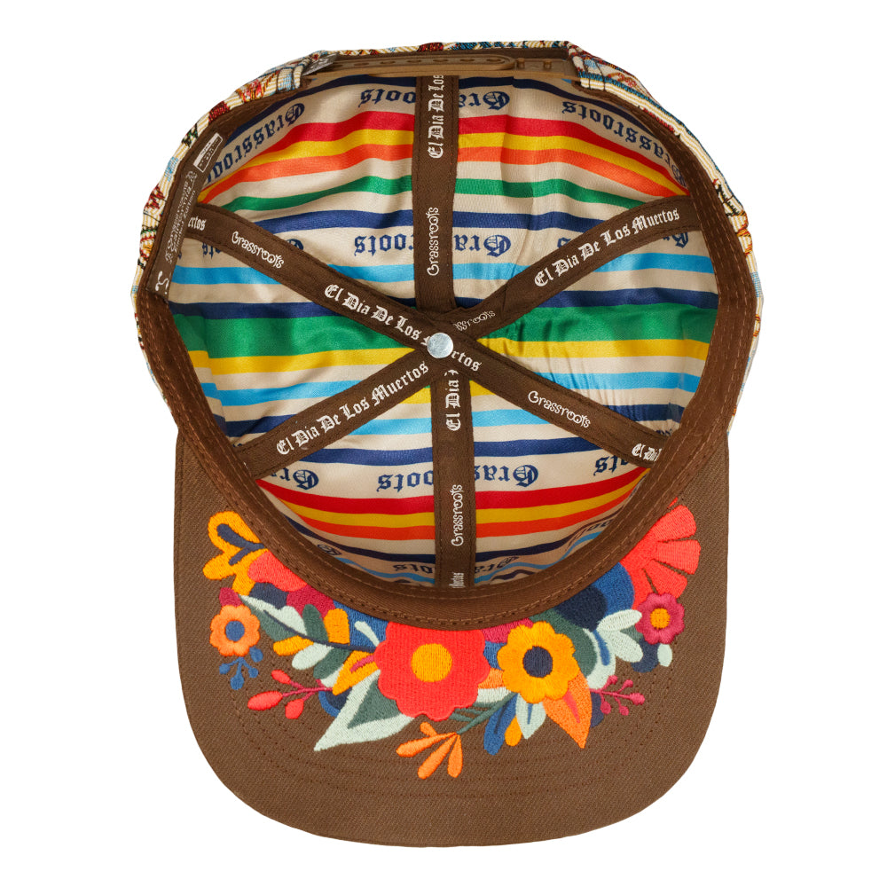 Brown snapback hat with multicolor striped inner band and printed logos