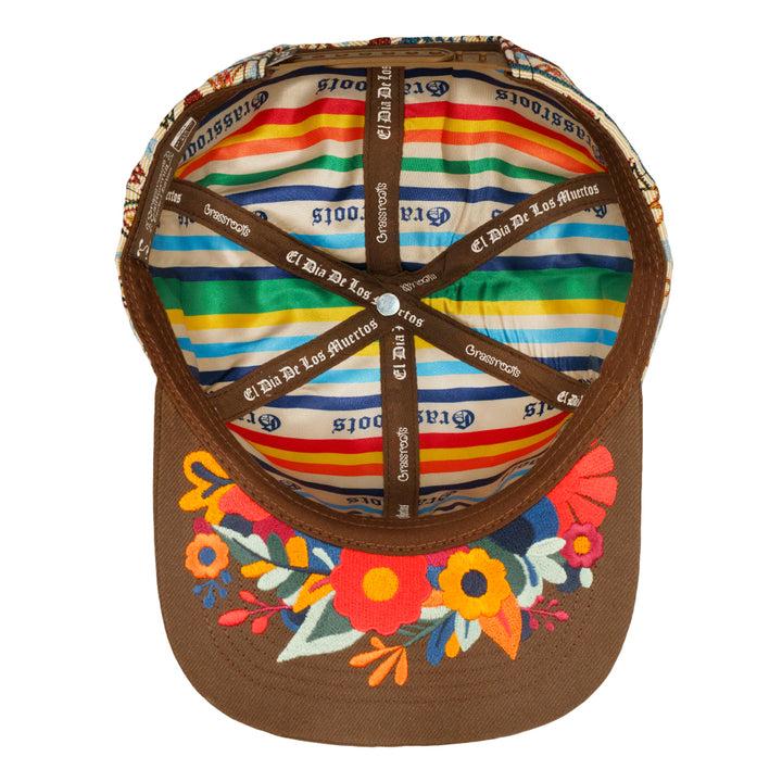 Brown snapback hat with multicolor striped inner band and printed logos